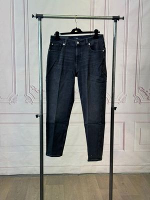 a pair of jeans hanging on a clothes rack in a room