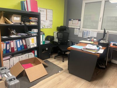 une pièce avec un bureau, une chaise, une bibliothèque et une chaise