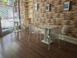 une table et des chaises dans une pièce dont l'un des murs est en briques