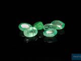 a pair of emeralds on a black surface