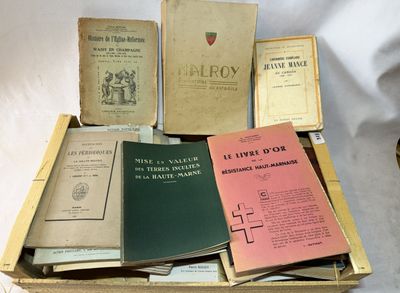 de nombreux livres qui sont rangés dans une boîte posée sur une table