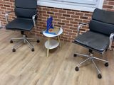 two chairs and a table in front of a brick wall