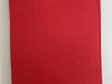 the red book is sitting on a white surface with a blue piece of paper sticking out of it