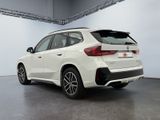 the rear end of a white bmw suv parked in a garage