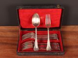 silverware in a red case on a wooden table with a black background