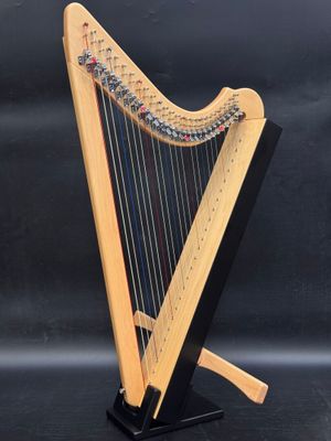 a wooden harp on a stand with a black background