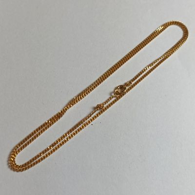 une chaîne en or avec un fermoir sur un fond blanc