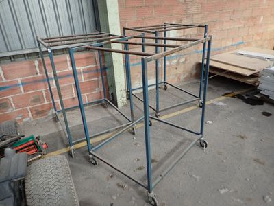a metal rack that has wheels on it in front of a brick wall
