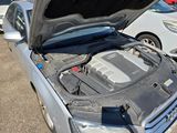 a silver car with its hood open in a parking lot