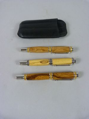 trois stylos et un pot à stylos posés sur une table