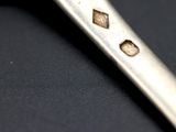 a close up of a silver spoon on a black surface