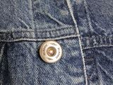 a close up of a denim jacket with a button on it