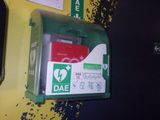 une armoire de secours verte et rouge sur un mur jaune