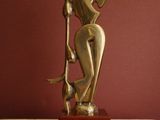 statue of a woman sitting on a stool with a cane