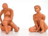 deux figurines représentant un homme et une femme assis par terre