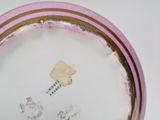 a pink and gold plate with a picture on it