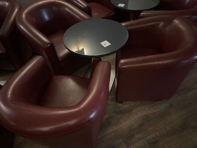 de nombreuses chaises et tables dans une pièce où est accrochée une horloge au mur