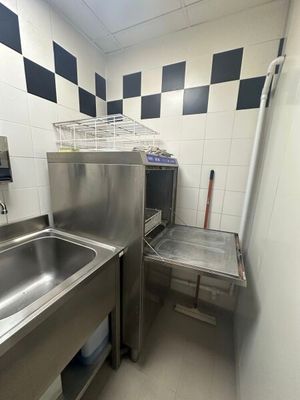 un évier en inox dans une cuisine aux murs à carreaux