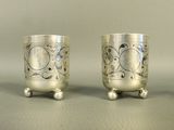two silver cups sitting next to each other on a table