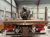 a truck with a motorcycle on the back of it in a warehouse