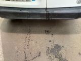 the rear end of a white van with black marks on the pavement