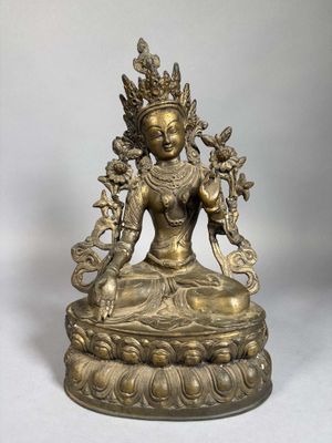 a bronze statue of a woman in a lotus position