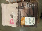 a bag of dog food sitting on the floor next to a bag of dog food