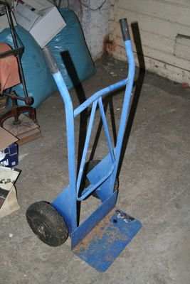 un diable bleu avec une poignée noire dans un garage