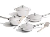 plusieurs casseroles et poêles blanches posées sur une table blanche