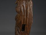 an old wooden statue of a man with a bird on his shoulder