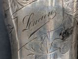 a silver cup with writing on it sitting on a table