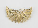 a close up of a gold butterfly brooch on a white background