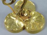 a gold plate with a flower on it on a white surface