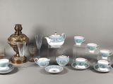 de nombreuses tasses et soucoupes posées sur une table à côté d'un vase
