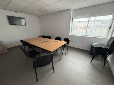 tables and chairs in a room with a flat screen tv on the wall
