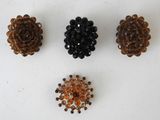 three small beaded flower brooches are shown on a white surface