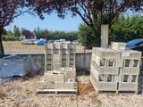 a pile of concrete blocks sitting on the ground next to a fence