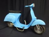 a blue scooter that is sitting on a black background