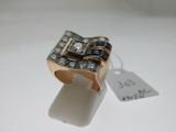 une photo d'une bague sertie d'un diamant et d'un saphir, en or rose 18 carats