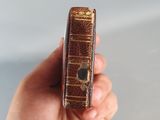 a person holding a small book in their hand