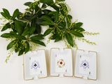 four small white and gold plates with flowers and leaves on them