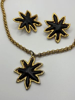 a close up of a necklace and earrings on a white surface