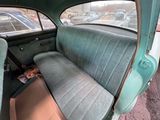 a green car with a blue seat and a brown box in the back