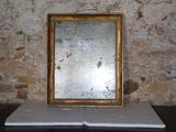 une photo d'un miroir posé sur une table devant un mur de briques