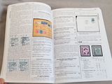 a person holding an open book with stamps on it