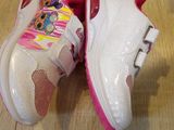 a pair of pink and white shoes on a wooden floor