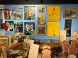 une pièce remplie de nombreux tableaux et de chaises