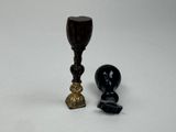 une bougie noire et un bougeoir doré placés l'un à côté de l'autre