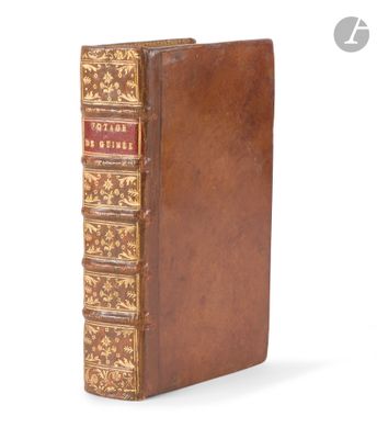 an old book with a brown cover sitting on top of a white surface