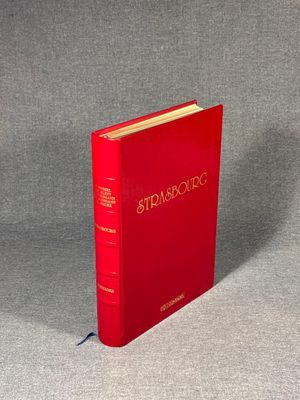 the red book is sitting on a gray surface with a gray background